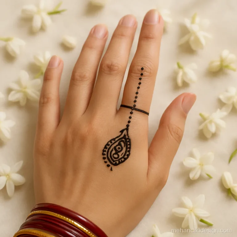 Simple mehandi pic of one paisley on the ring finger with dotted lines